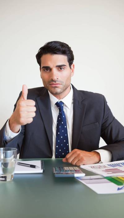 Portrait of a businessman with the thumb up in his office